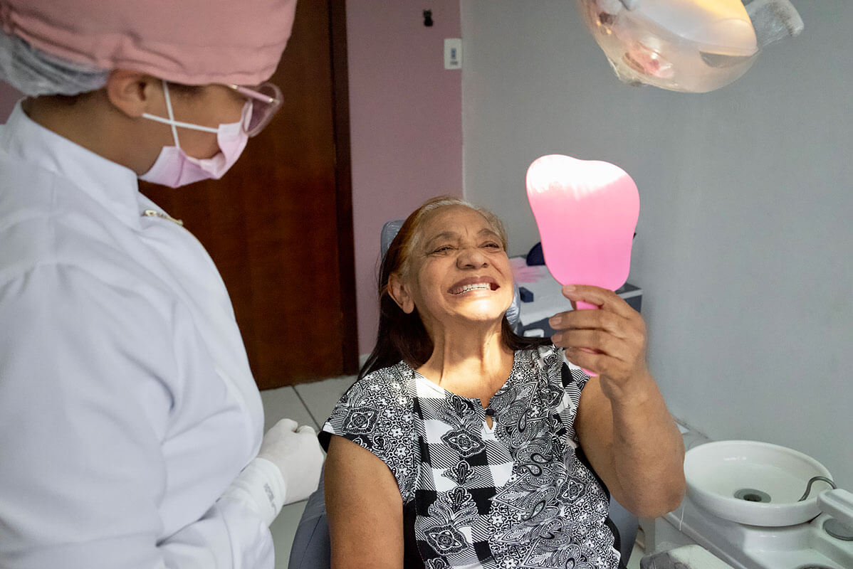 elderly-woman-checking-smile-with-dentist